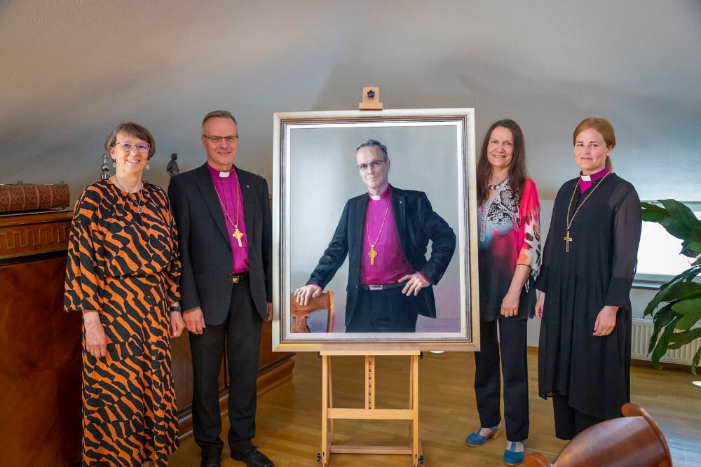 Arkkipiispa Tapio Luoman muotokuvan ympärillä arkkipiispan puoliso Pirjo Luoma, arkkipiispa Luoma, kuvataiteilija Tiina Vainio sekä piispa Mari Leppänen.