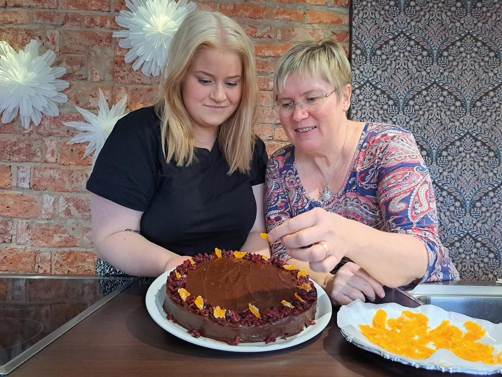 Mia och Matilda Jåfs garnerar en kaka