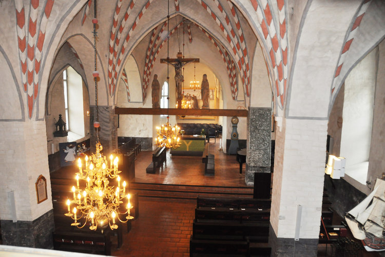 Liedon keskiaikaisen kirkon sisätilat. Katossa holvikaaret sekä krusifiksi.