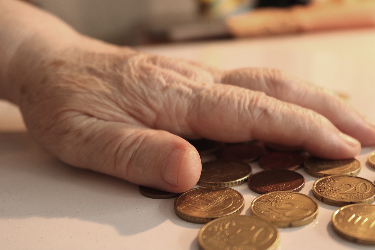 Vanhan ihmisen käsi laskee rahoja.