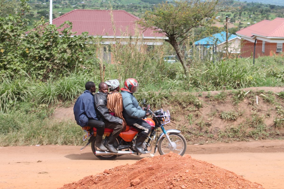 Four men driving with the same scooter.