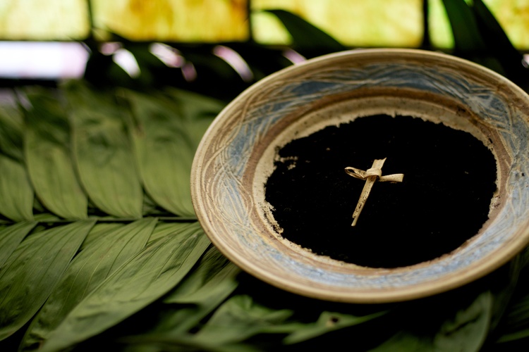 A cross on a plate containing ash.