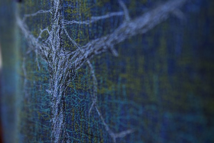 Närbild av textilkonstverk i blått och grönt.