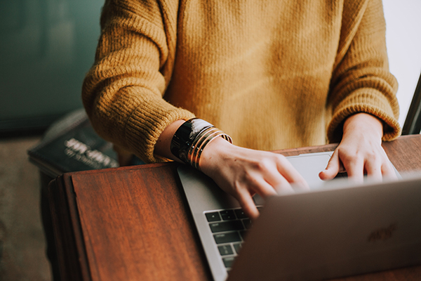 Opiskelija näpyttelee kannettavaa tietokonetta luentosalissa. Kuvaaja: Christin Hume, Unsplash.com