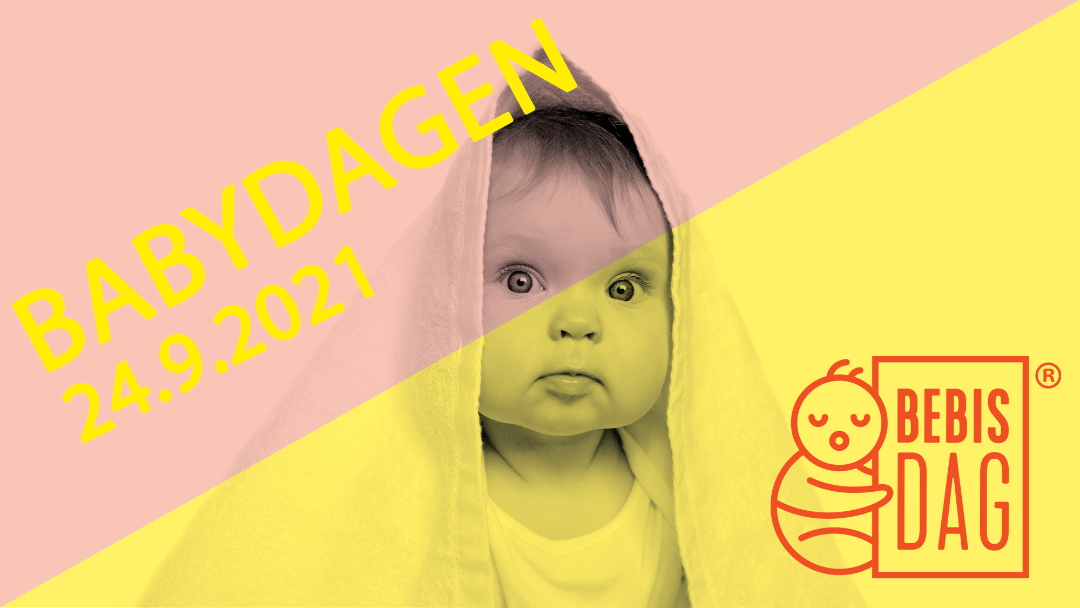 Sittande baby med ett badlakan runt sig
