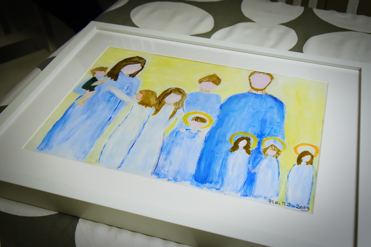 Piritta har målat en tavla som beskriv¬er familjen såsom den är. För barnen är det viktigt att säga att det finns åtta barn i familjen. 
