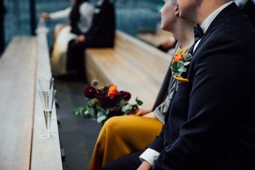Kuvassa pariskunta istuu kirkon penkissä Vantaan Hääyö-etkoilla. Morsiamella on keltainen puku ja kukkakimppu kädessä. Heidän edessään on lasilliset kuohuvaa.