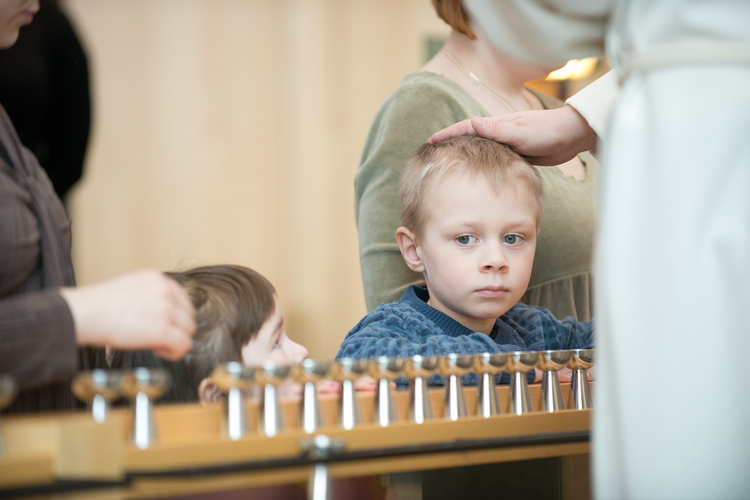 lapsi siunataan ehtoollispöydän ääressä