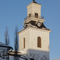 Kirkon kellotapuli sinistä taivasta vasten.