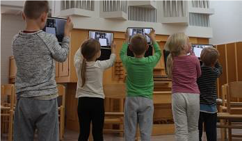 Barn fotograferar kyrkorgel med pekplattor