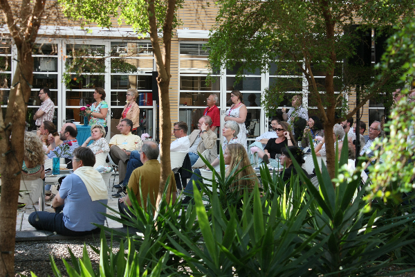 Festival participants sitting in the wintergarden of the local tv-station. A lot oftrees and plants.