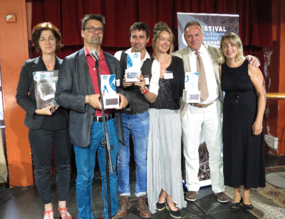 Six persons standing on the stage with prizes in their hands