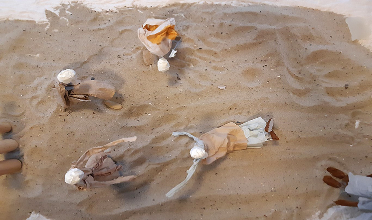 Askarreltuja ihmishahmoja hiekassa.