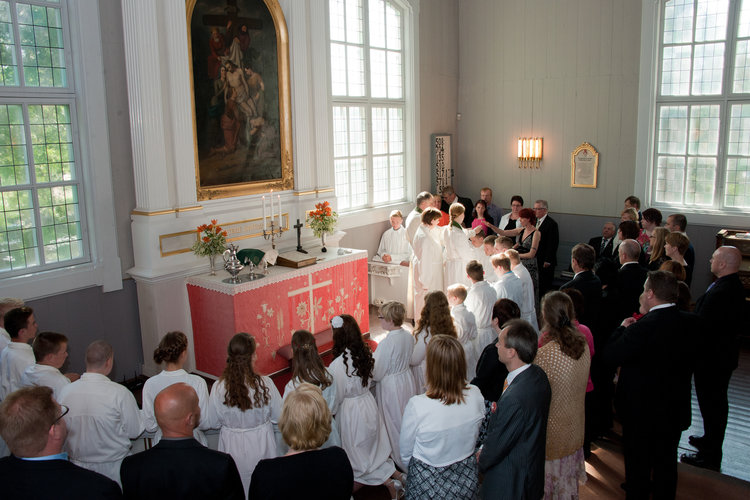 Konfirmaatio Yläneen kirkossa. Kummit siunaavat konfirmoitavat nuoret alttarilla.