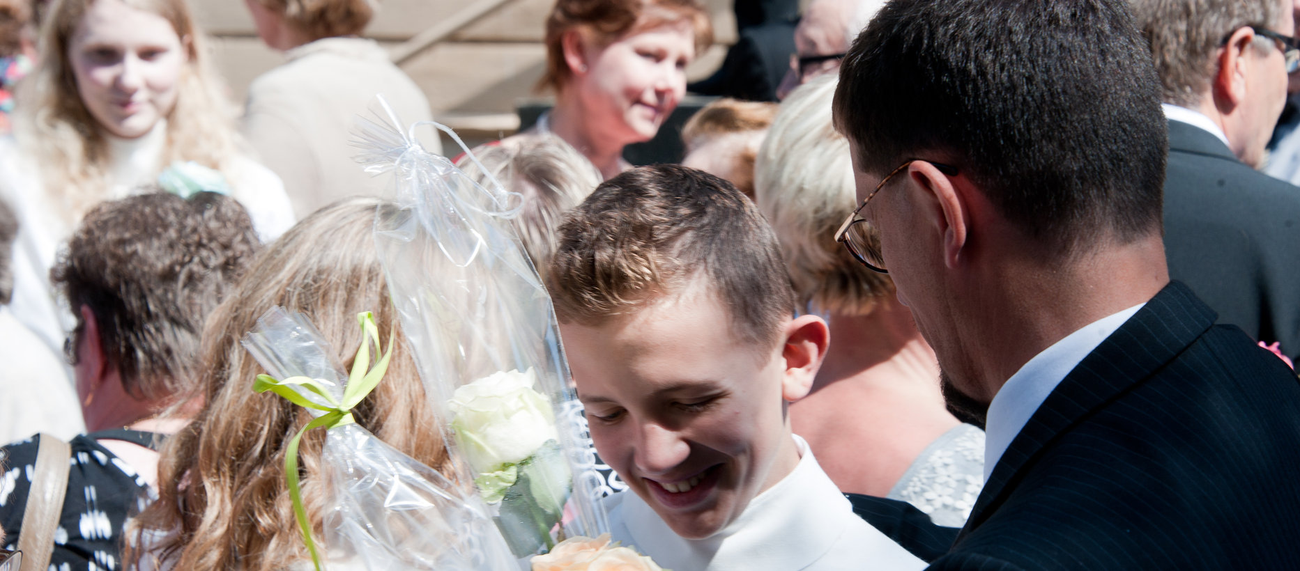 Nuoria onnitellaan kirkon pihalla konfirmaation jälkeen.
