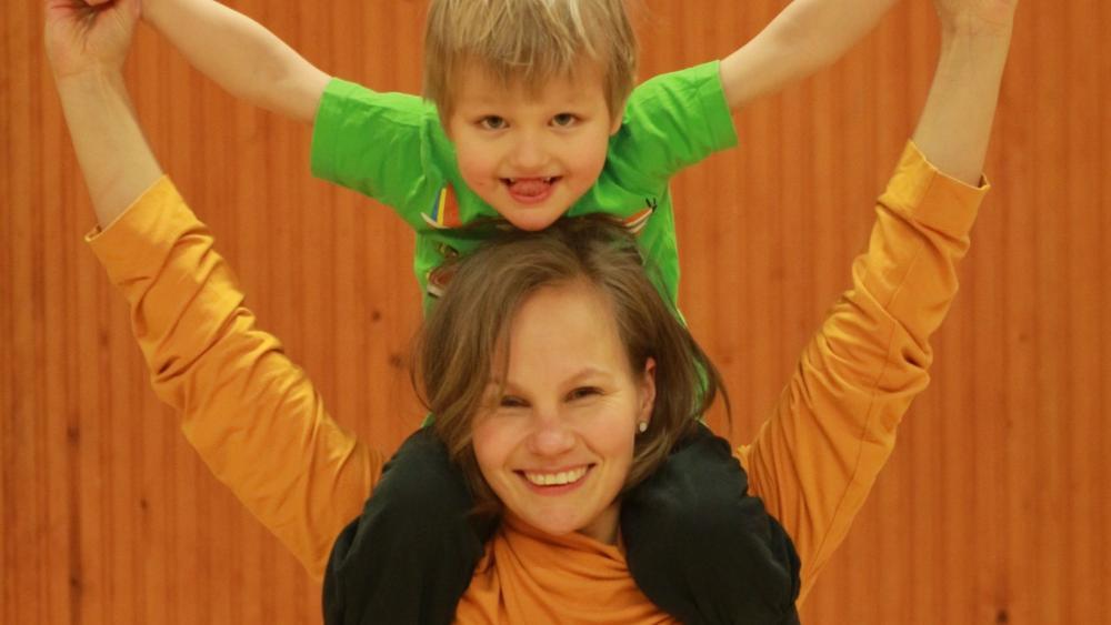 En kvinna bär en pojke på axlarna