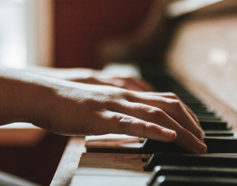 Händer spelar piano.