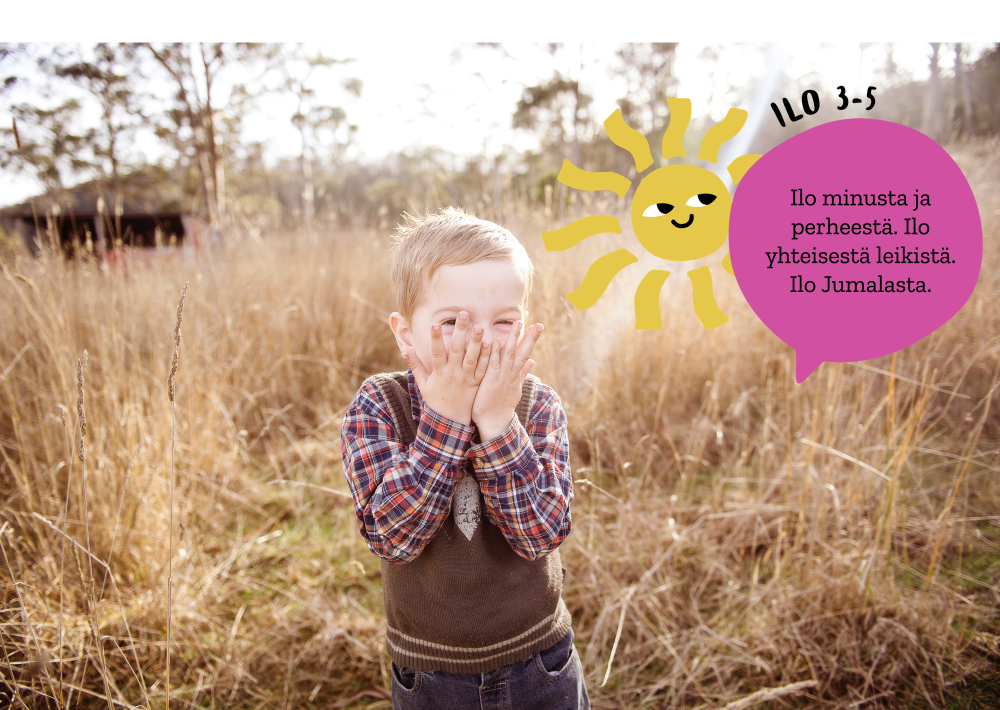Kuvassa naurava lapsi seisoo kädet suun edessä heinäpeltoa taustallaan.