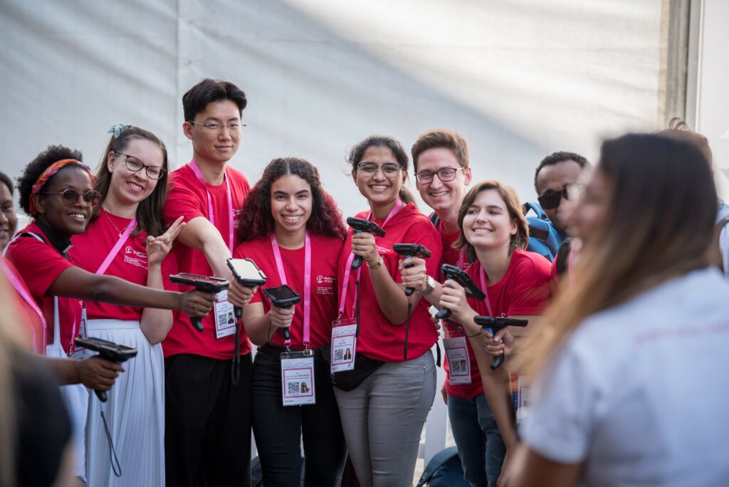 En grupp unga människor av olika nationaliteter klädda i matchande röda t-skjortor.