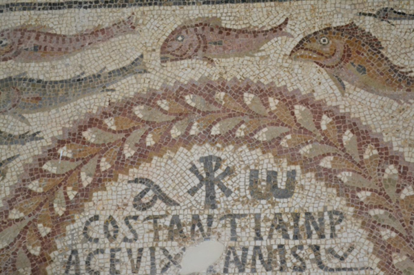 Gammal mosaik med fiskar, text och symboler.