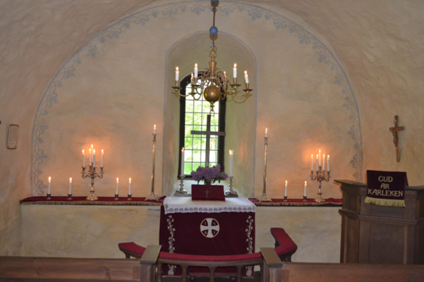 Altaret med kors och ljus i en gammal kyrka.