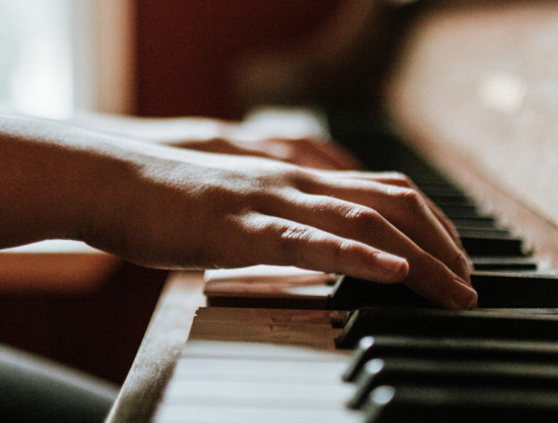 Närbild på händer som rör sig över pianotangenter.