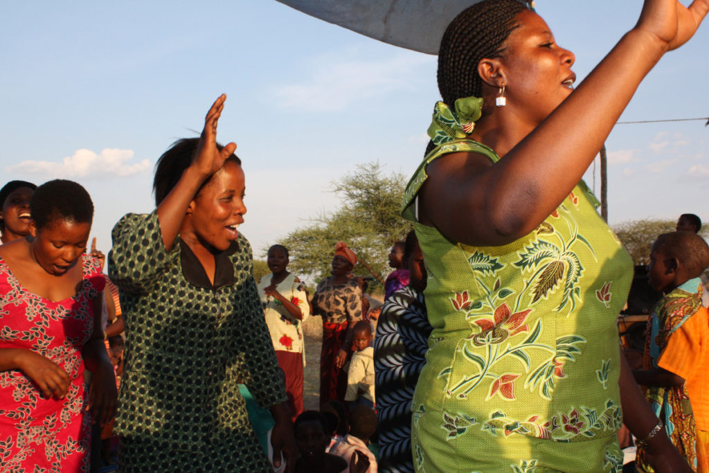 Naiset tanssivat auringonpaisteessa Afrikassa.
