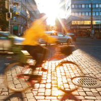 Cykel rör sig längs stadsgata, suddig av farten.