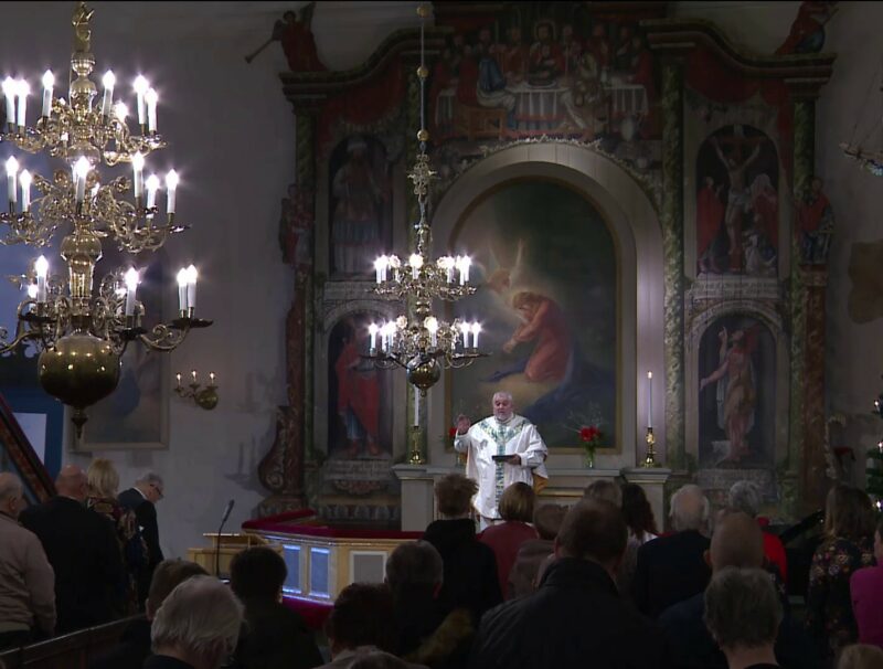 Kyrkoherde Per Stenberg står framför altaret i Karleby sockenkyrka.