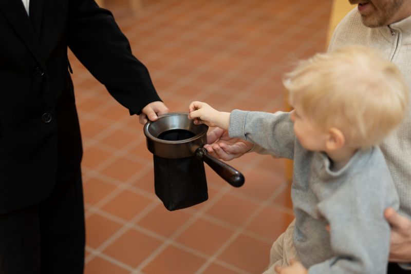 Kollekt i kyrkan. Ett barn lägger pengar i kollekthåven.